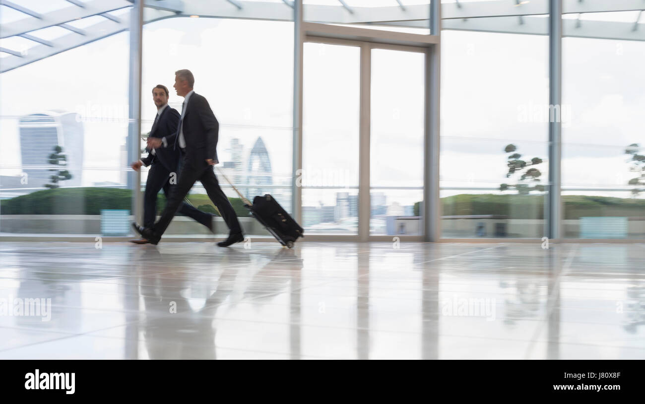 Geschäftsleute gehen und ziehen Koffer im Flughafen Stockfoto