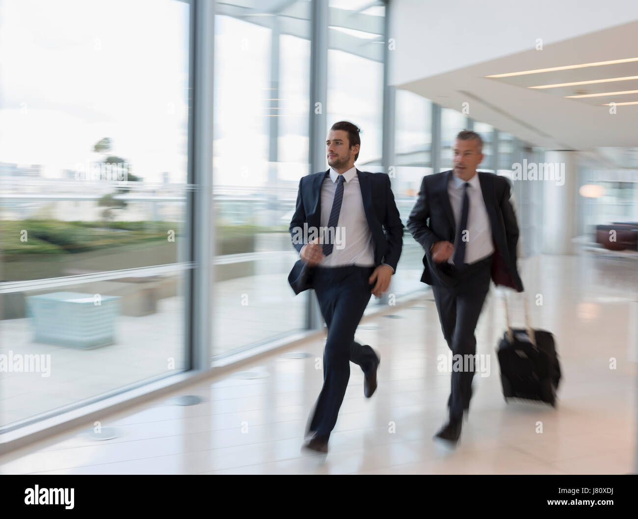 Geschäftsleute, laufen, eilen mit Koffer im Flughafen Stockfoto