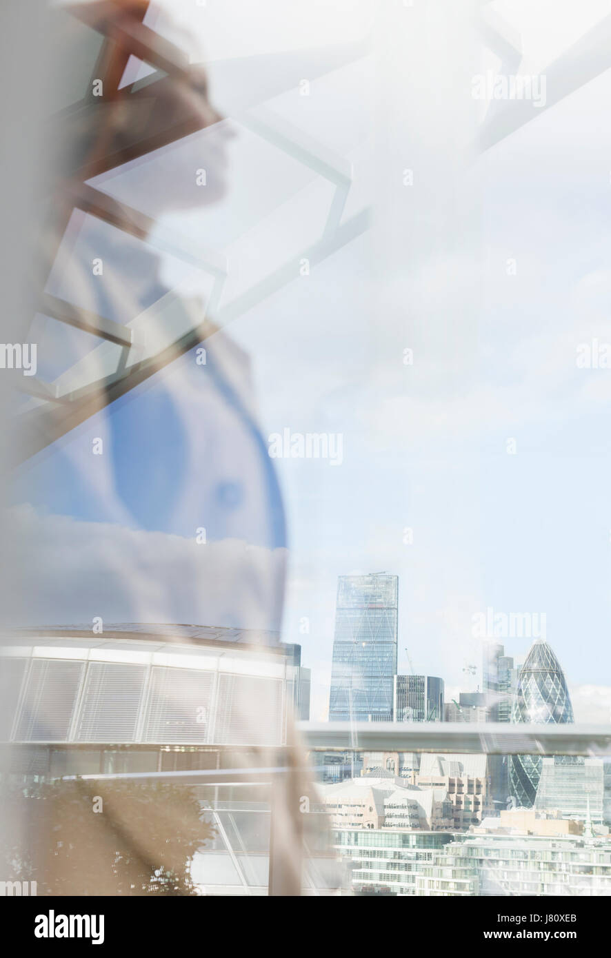 Nachdenklich Geschäftsfrau Blick auf Blick auf die Stadt aus städtischen Balkon, London, UK Stockfoto