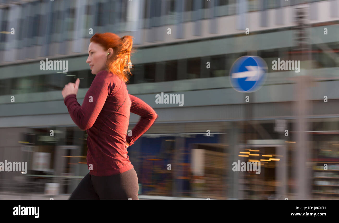 Weibliche Läufer entlang Städtebau Stockfoto