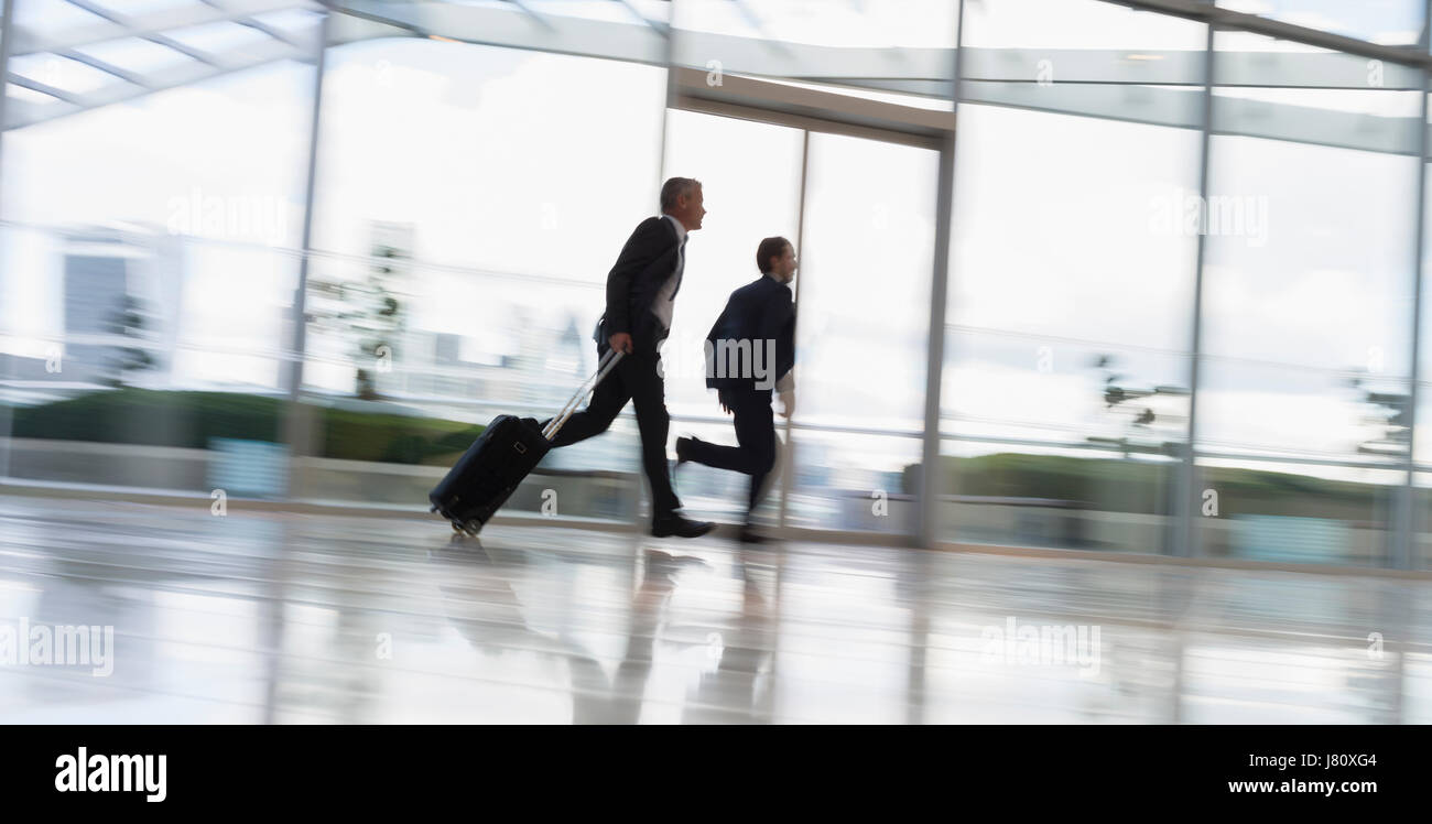 Geschäftsleute mit Koffer, Rauschen in Flughafen Stockfoto
