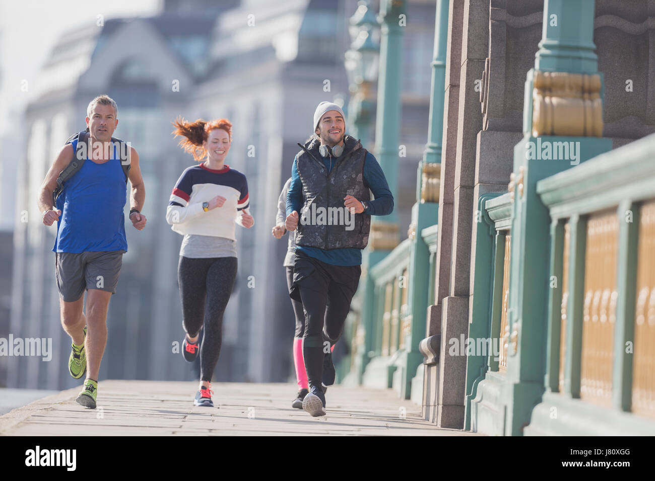 Läufer laufen auf sonnigen städtischen Bürgersteig Stockfoto