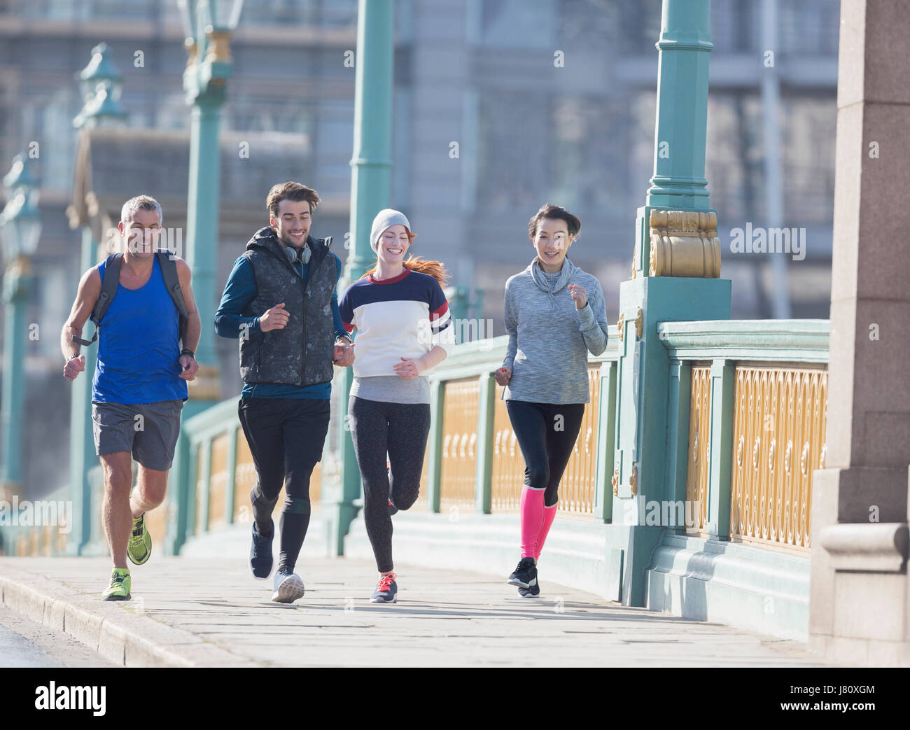 Läufer laufen auf sonnigen städtischen Bürgersteig Stockfoto