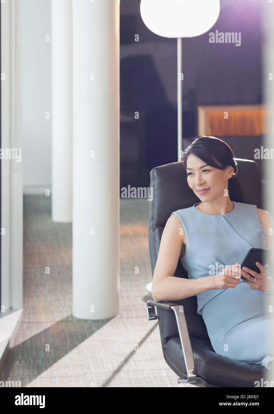 Geschäftsfrau mit Handy im Büro lounge Stockfoto