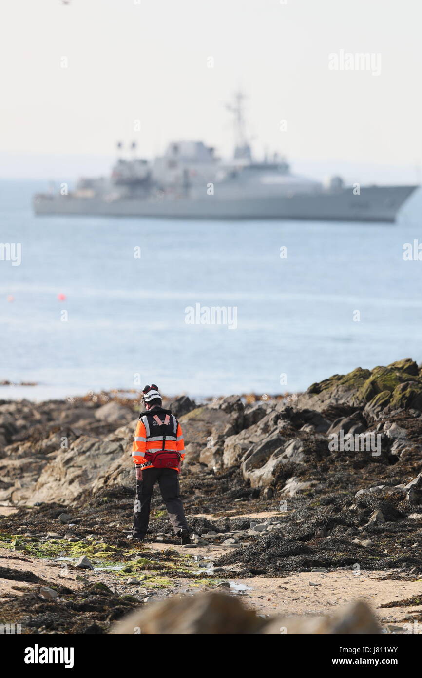 Mitglied der Irish Coast Guard durchsucht die Küste in den Schären, die Suche und Rettung Betrieb im Gange für einen fehlenden Fischer, ist nachdem ein Boot in der irischen See versank. Stockfoto