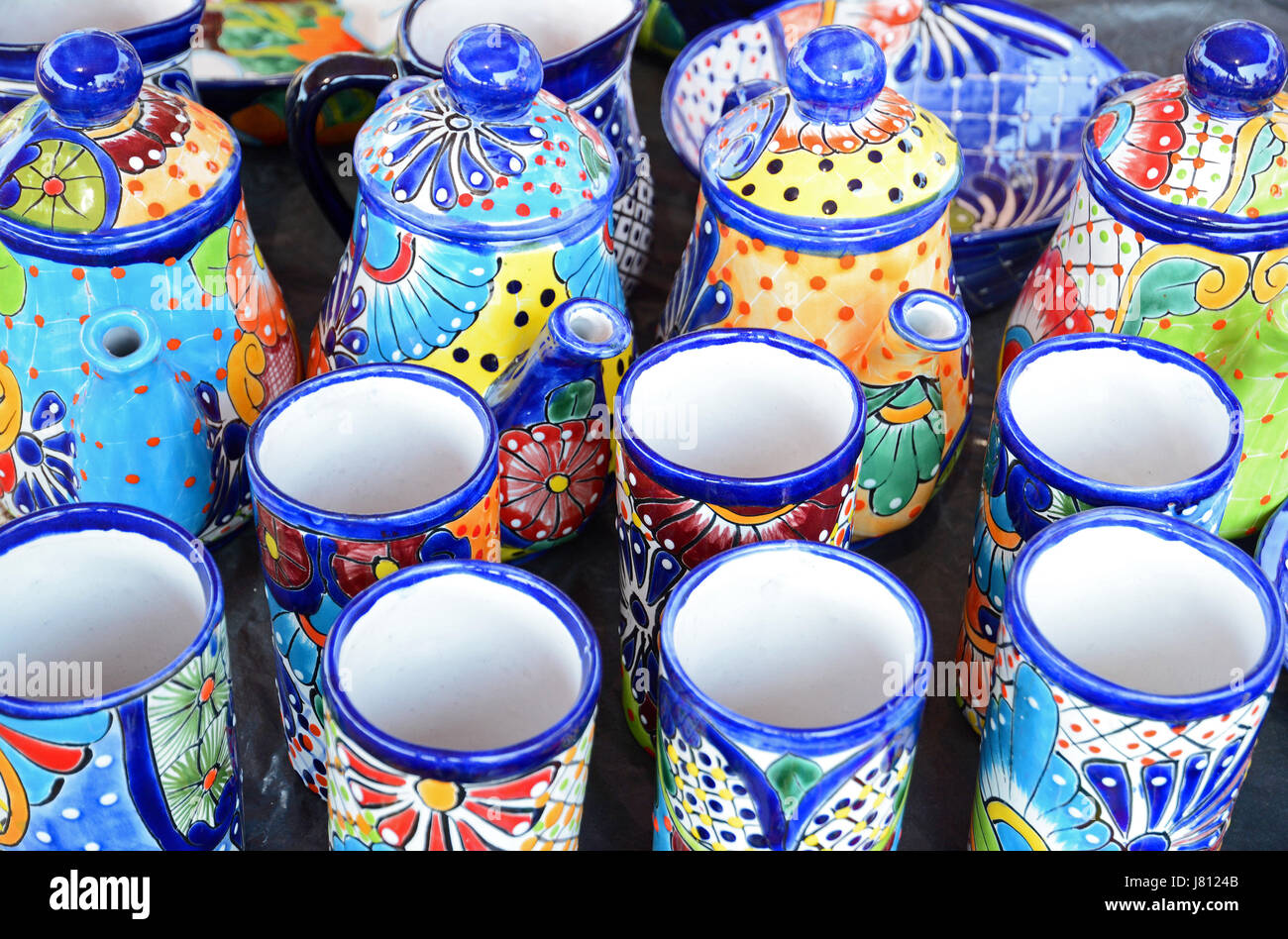 Mexikanische handgemachte Töpferbecher, Tassen und Teekannen mit farbenfrohen Designs Stockfoto