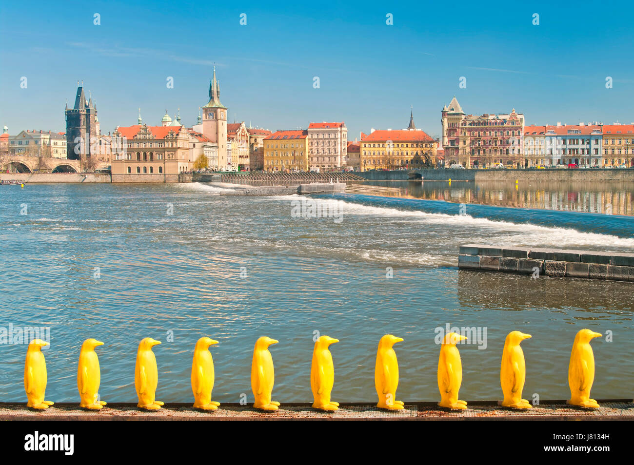 Pinguine am Kampa Park im Vordergrund gelb und Blick auf die Altstadt Gebäude und die Karlsbrücke über die Moldau im Hintergrund, Prag, Tschechien Stockfoto