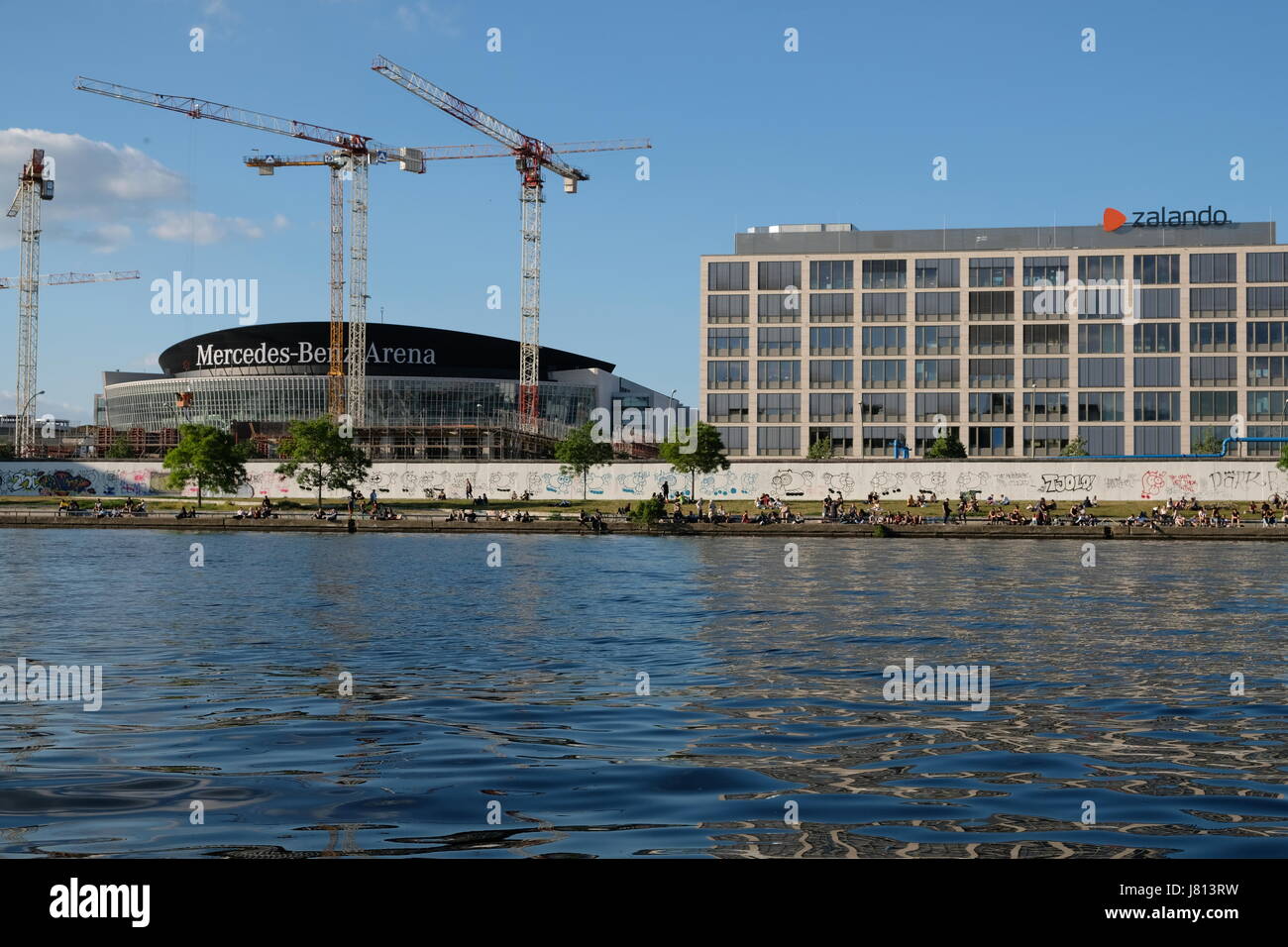 Berlin, Deutschland - 26. Mai 2017: Leute sitzen im Riverside neben der Berliner Mauer in der East Side Gallery in Berlin. Stockfoto