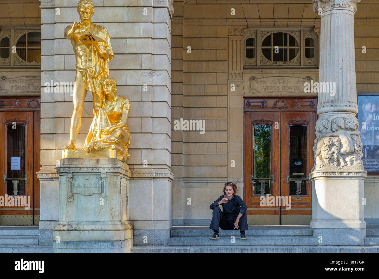 Frau sitzt außerhalb des königlichen dramatischen Theaters in Stockholm. Nationale Phase Schwedens gegründet 1788 und die aktuellen Gebäude stammt aus dem Jahre 1908 Stockfoto