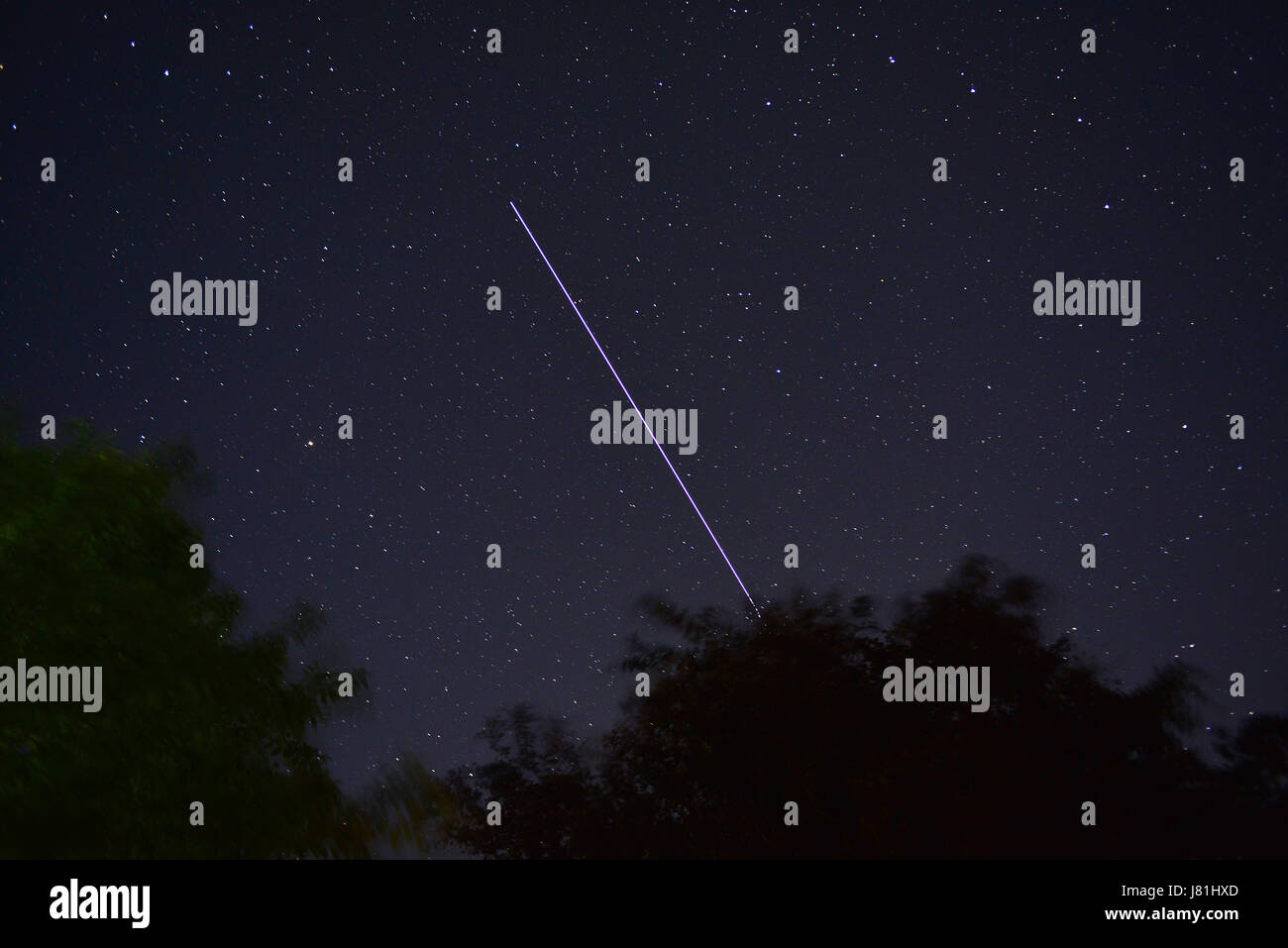 Aberystwyth, Wales, UK - zeigt eine Belichtungszeit von 30 Sekunden die Strecke von der internationalen Raumstation (ISS) über den Nachthimmel in West Wales kurz vor Mitternacht. Eine sanfte Brise bewegt sich die Blätter der Bäume im Vordergrund und der Himmel ist bemerkenswert klar nach einem hellen Sommertag - John Gilbey/Alamy Live News - 26 kann 2017 Credit: John Gilbey/Alamy Live News Stockfoto