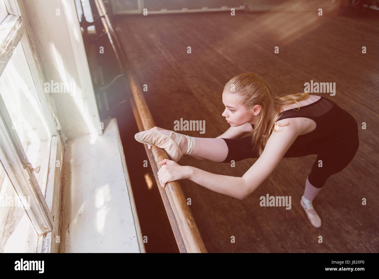 Weiblichen Balletttänzer stretching am Ballettstange. Oberen Geschossen. Stockfoto