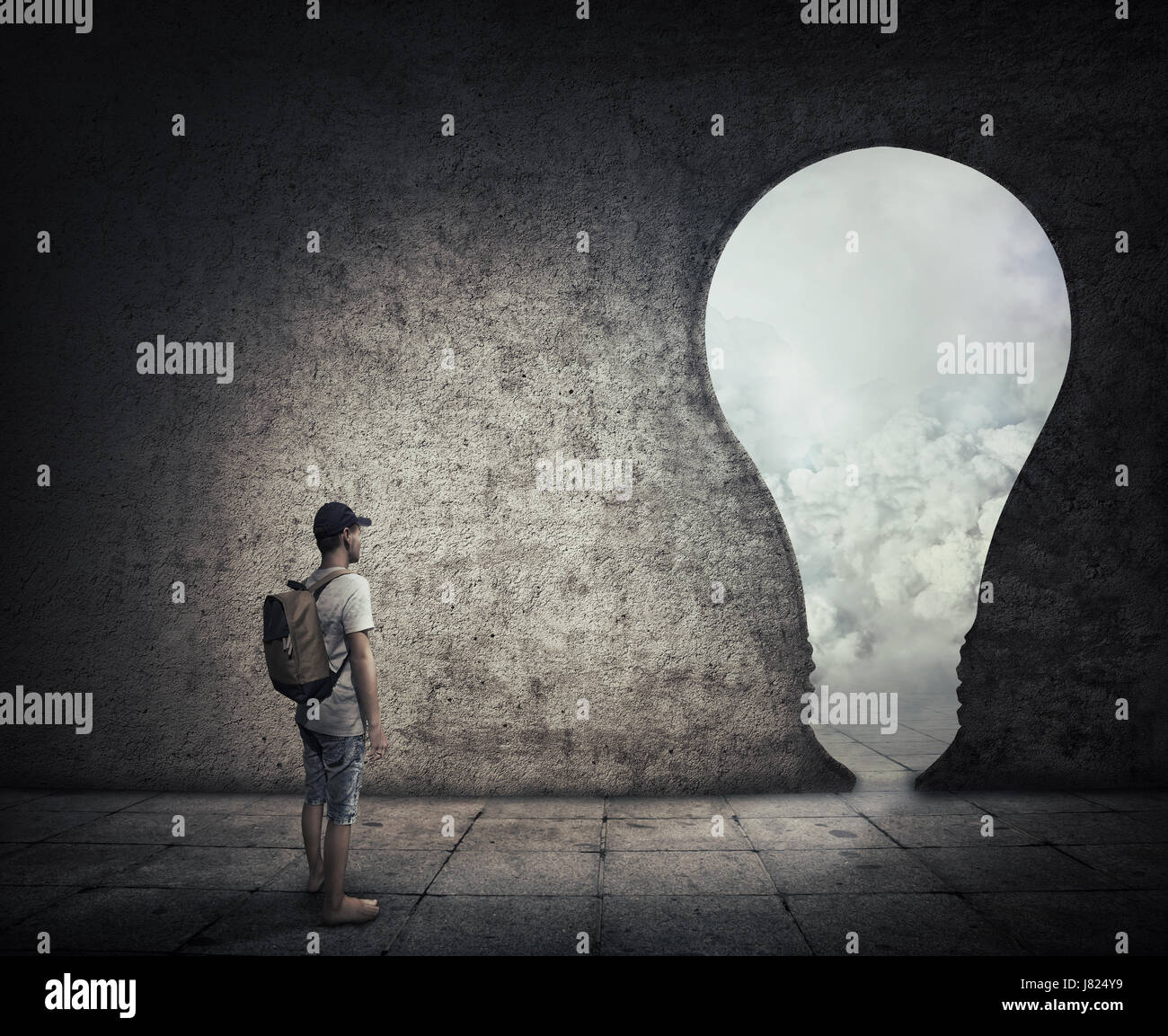 Konzeptbild mit einer Person in einem dunklen Raum vor einer Birne geformt Tür stehen. Möglichkeit, Eingang in eine andere Welt zu entkommen. Stockfoto