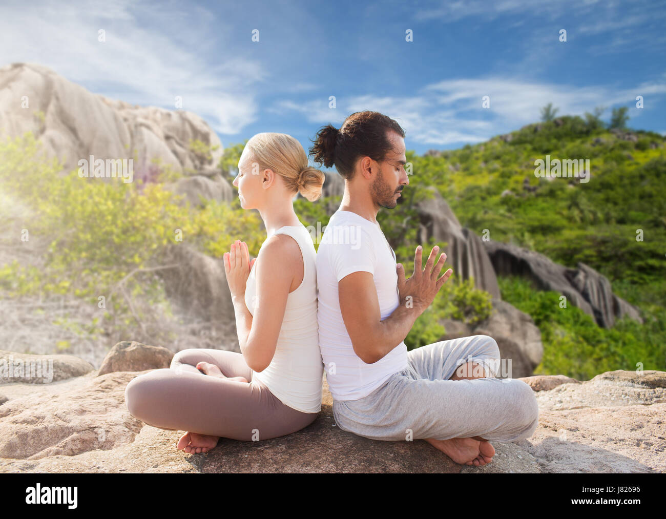 Lächelndes Paar machen Yoga Übungen im Freien Stockfoto