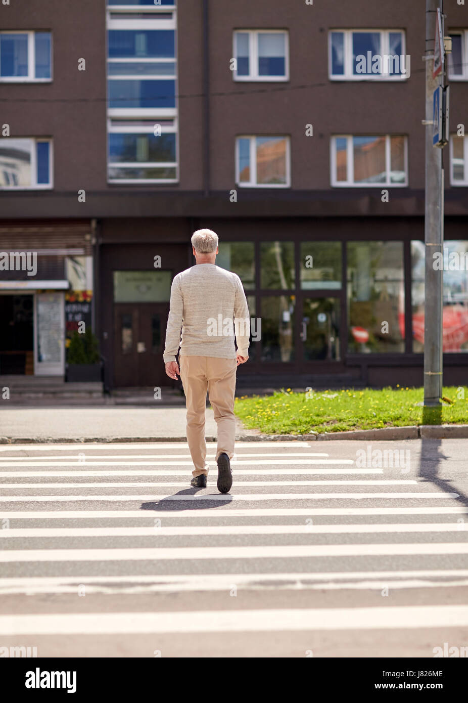 ältere Mann zu Fuß entlang Stadt Zebrastreifen Stockfoto