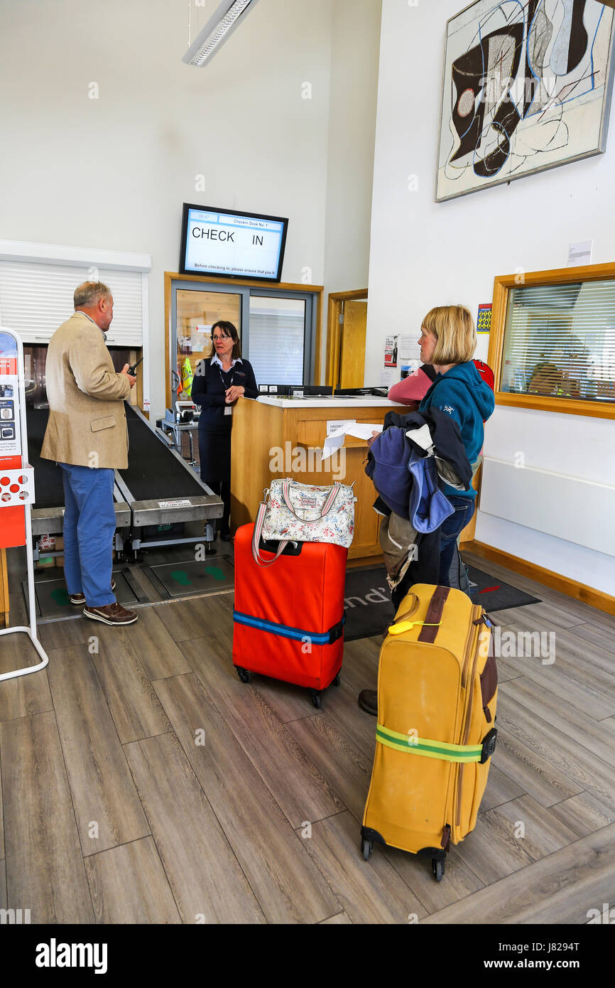 Passagiere warten mit ihren Koffern beim Check-in Schalter am Flughafen Endland, St. Just, Cornwall, England Stockfoto