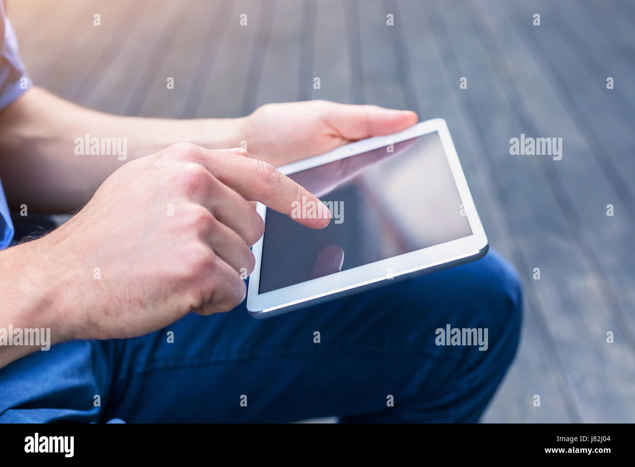 Lässige Person mit digitalen Tablettcomputer außerhalb mit w-LAN kommunizieren Stockfoto