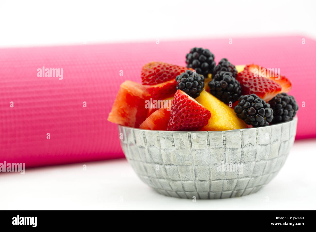 Gesundes Obst Schale mit Brombeeren, Erdbeeren, Melone und Wassermelone in Stilleben mit rosa Yogamatte. Stockfoto