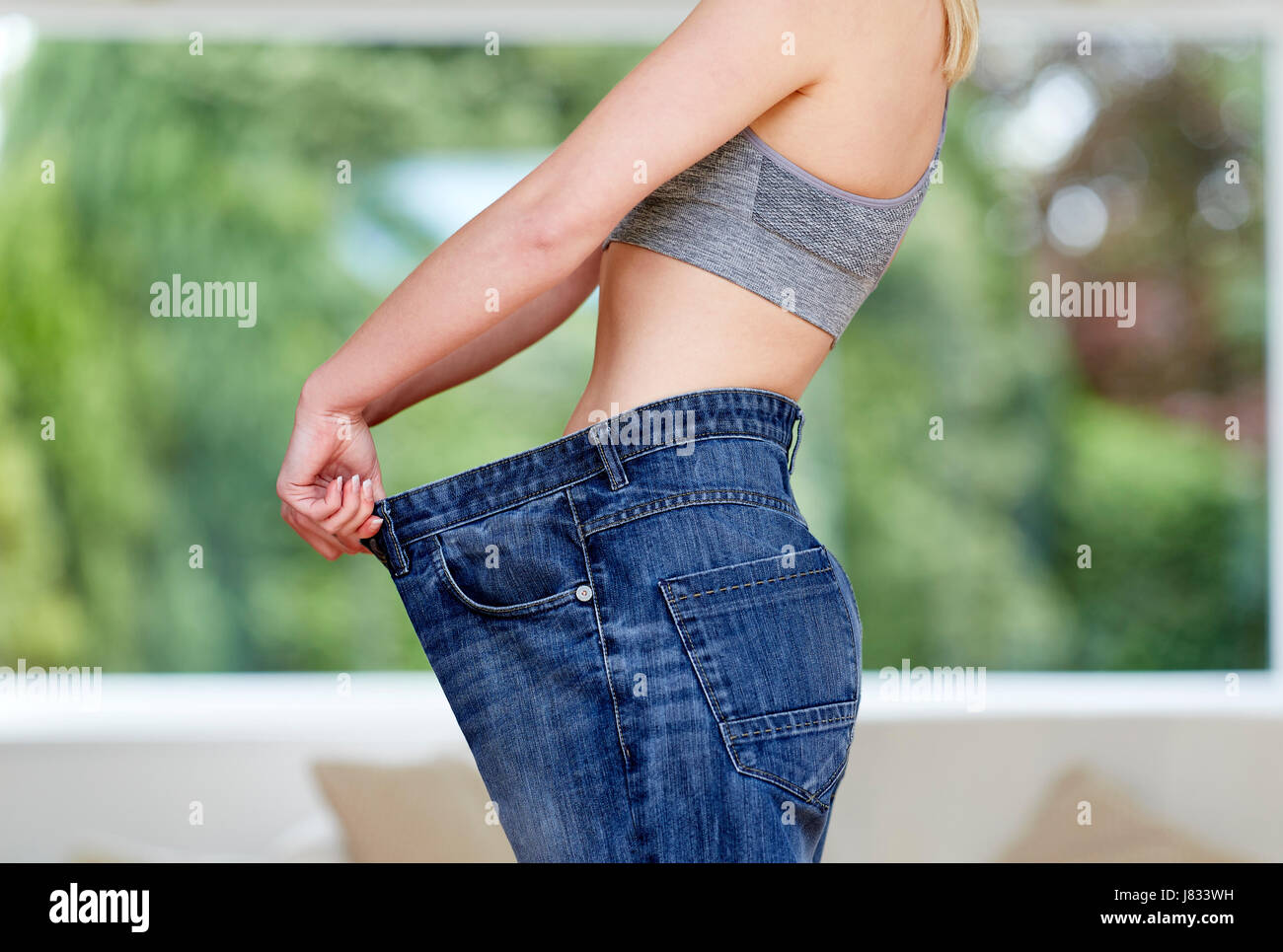 Mädchen mit großen Jeans - Gewicht-Verlust Stockfoto