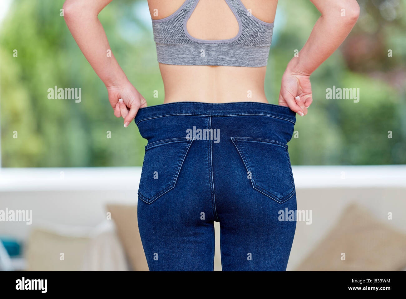 Mädchen mit großen Jeans - Gewicht-Verlust Stockfoto