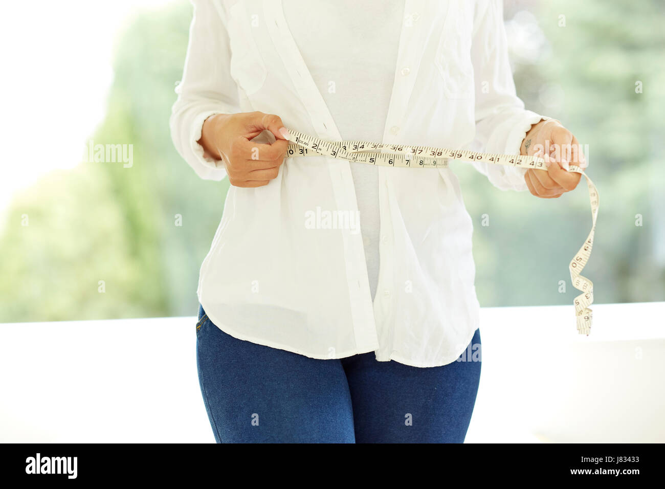 Frau mit Maßband um ihre Taille Stockfoto