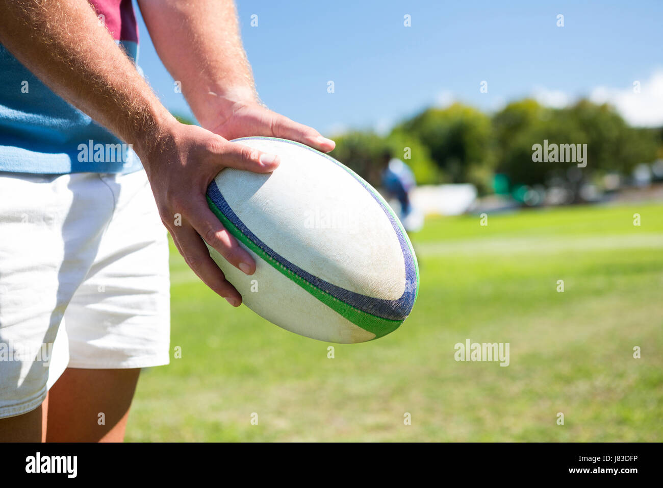 Nahaufnahme von Spieler mit Rugby-Ball stehend auf Wiese Stockfoto