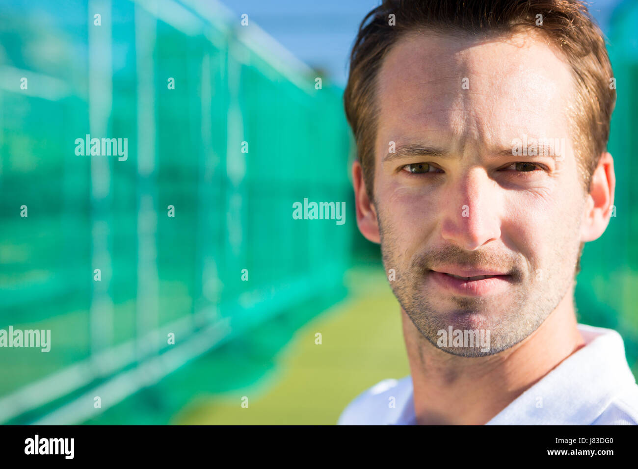 Porträt des jungen Cricketspieler gegen Netz auf Feld hautnah Stockfoto
