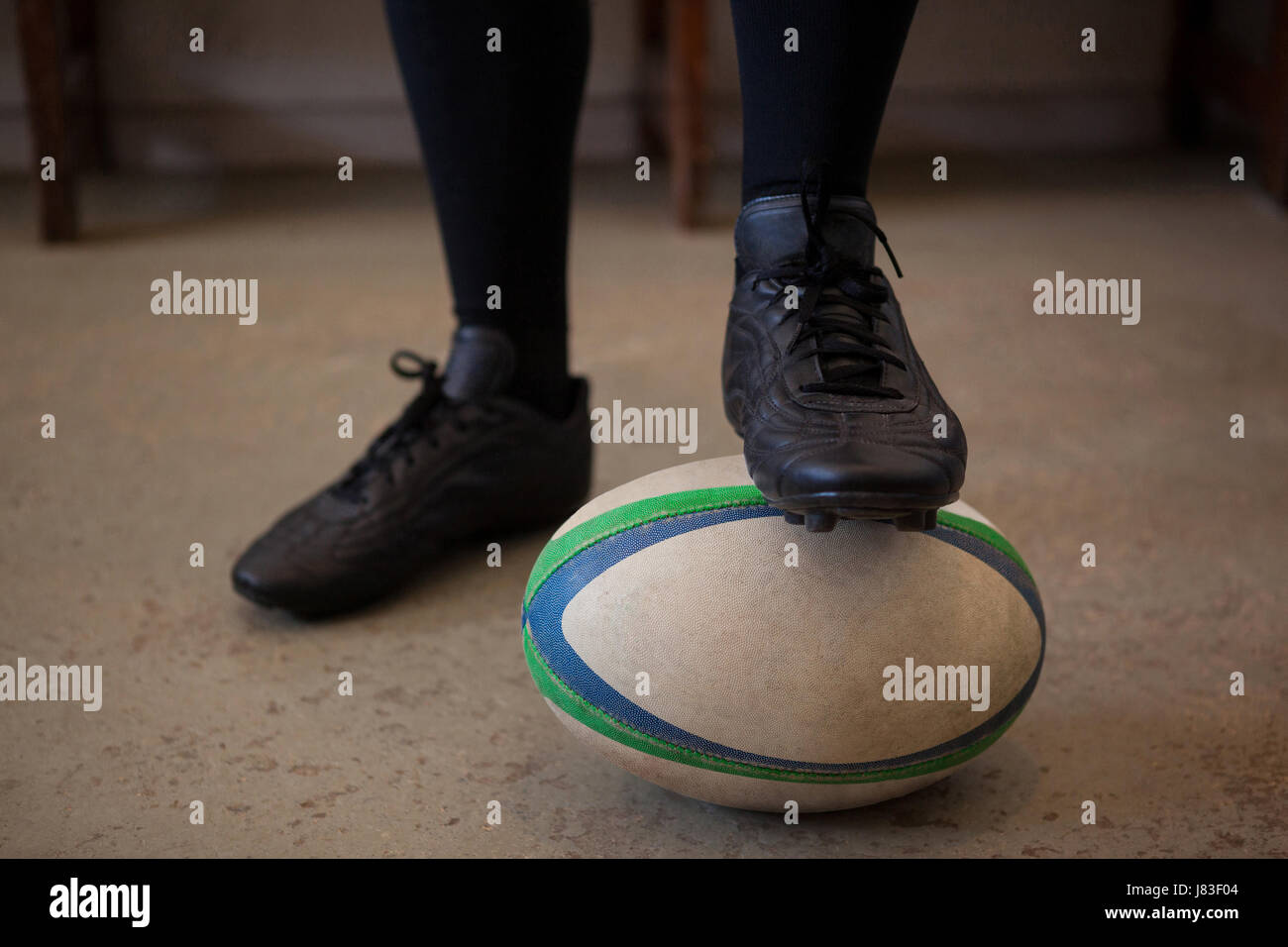 Geringen Teil der Spieler mit Bein auf Rugby-Ball im Umkleideraum Stockfoto