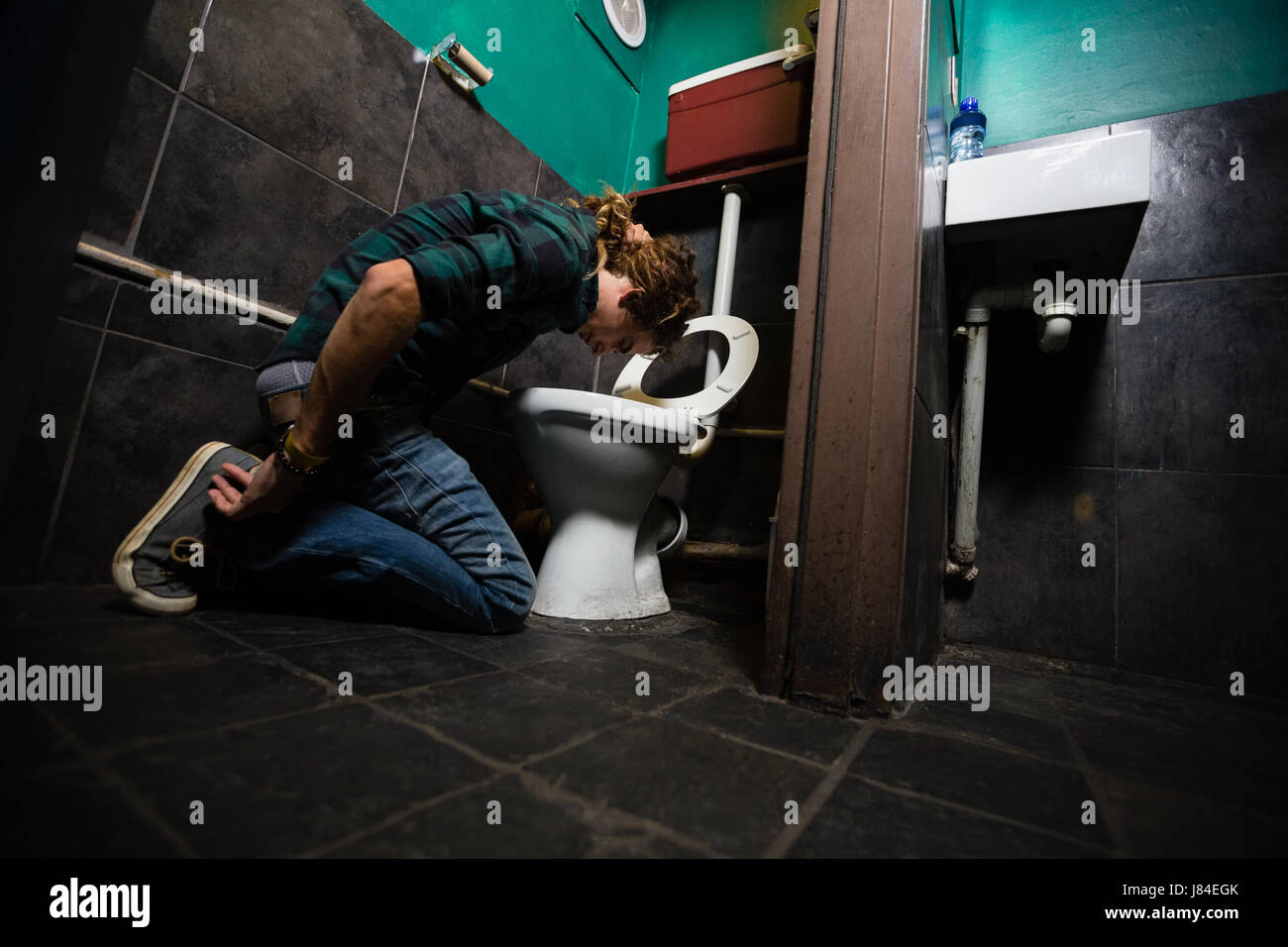 Mann, Erbrechen am Toilettenbecken im Waschraum Stockfoto