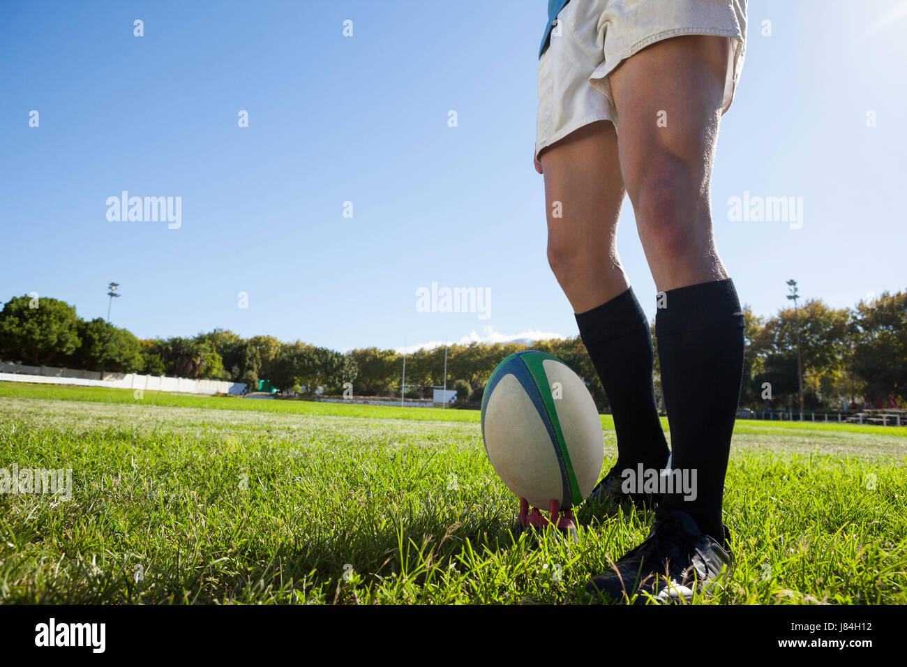 Geringer Teil der Spieler von Rugby-Ball auf Spielfeld gegen blauen Himmel Stockfoto