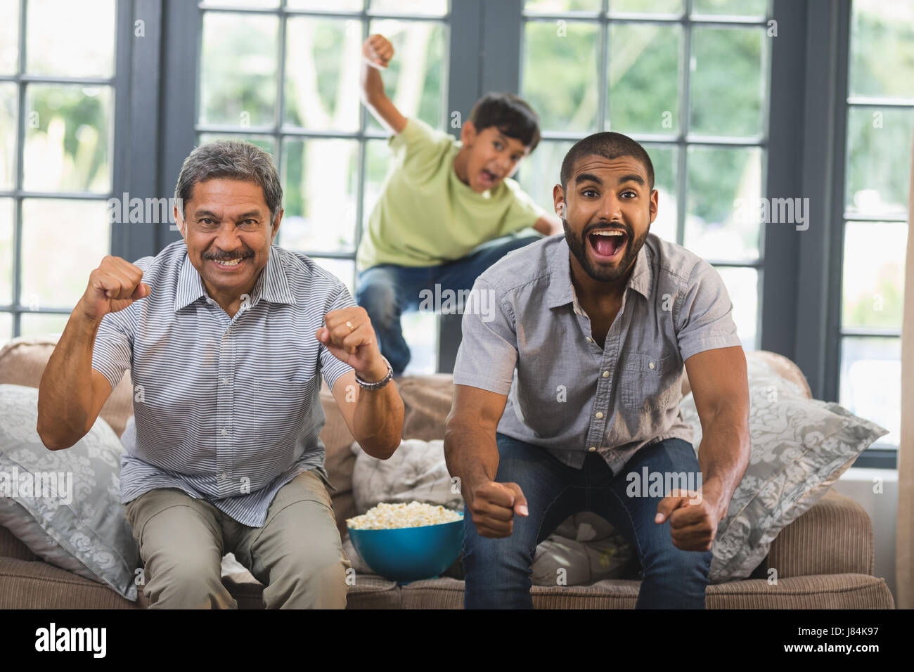 Fröhlich mehr-Generationen-Familie vor dem Fernseher zu Hause zusammen Stockfoto
