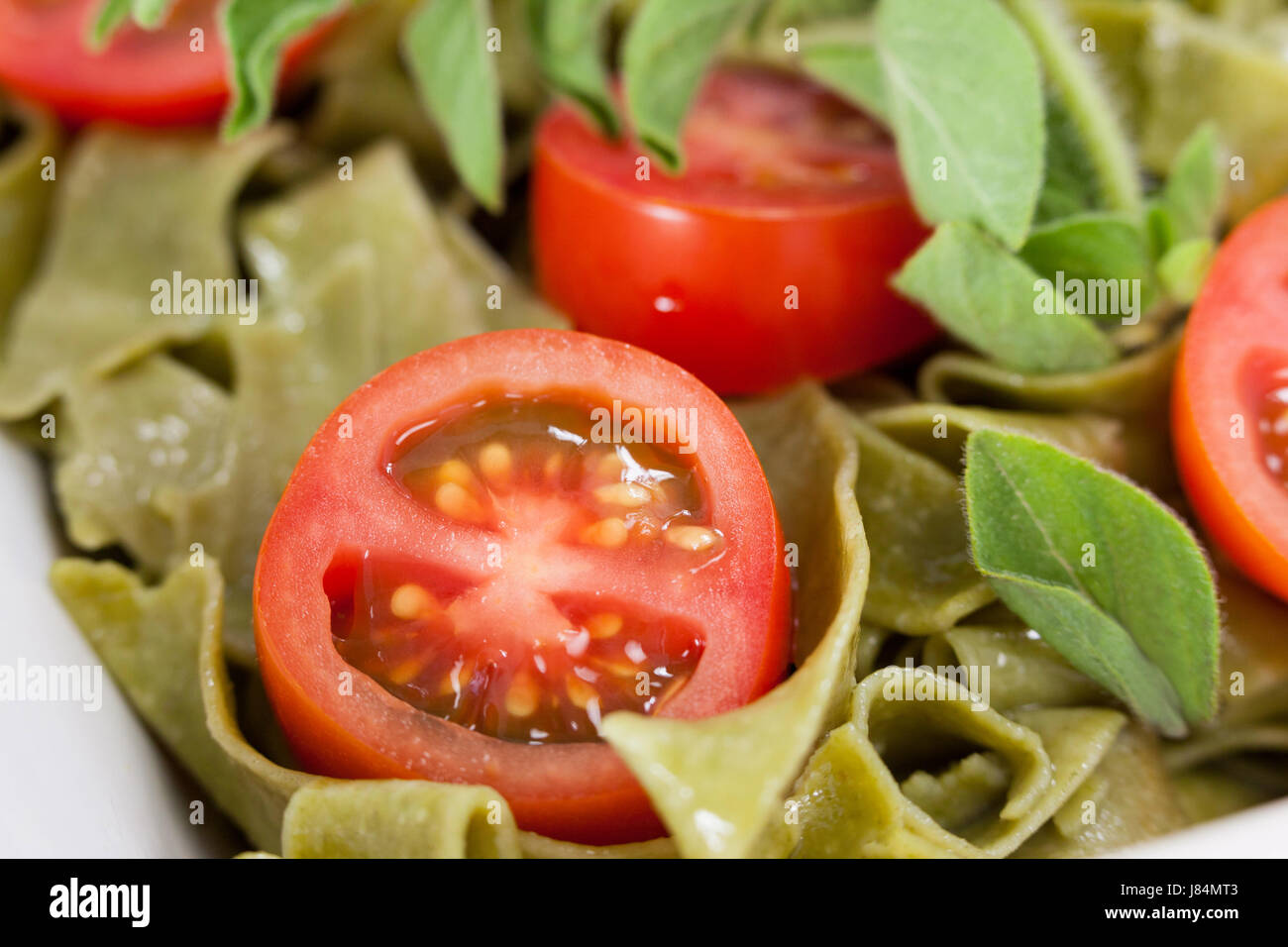 Nahaufnahme von Bandnudeln Spinat Pasta mit Tomaten und Kräutern Stockfoto