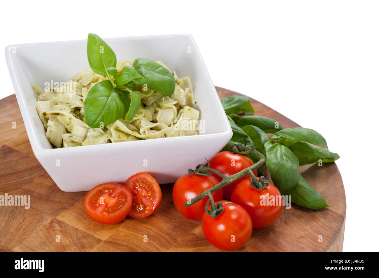 Fettuccine Nudeln mit Tomaten und Kräutern vor weißem Hintergrund Stockfoto