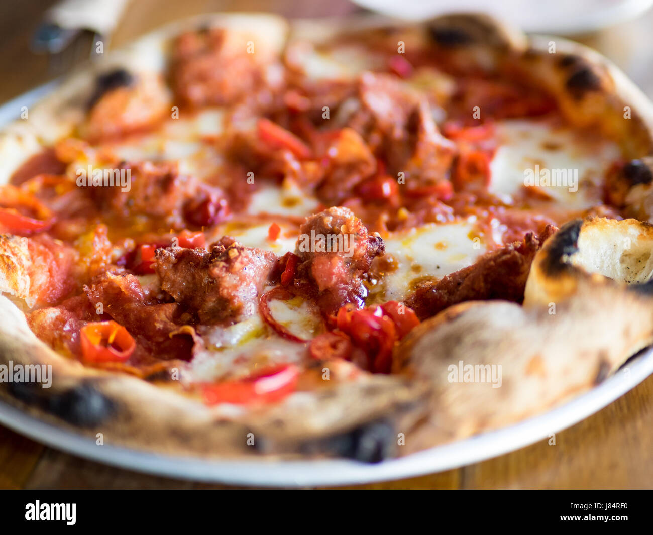 Eine neapolitanische Stil dünne Kruste Pizza mit italienischer Wurst und Peperoni aus Rosso Pizzeria in Edmonton, Alberta, Kanada. Stockfoto