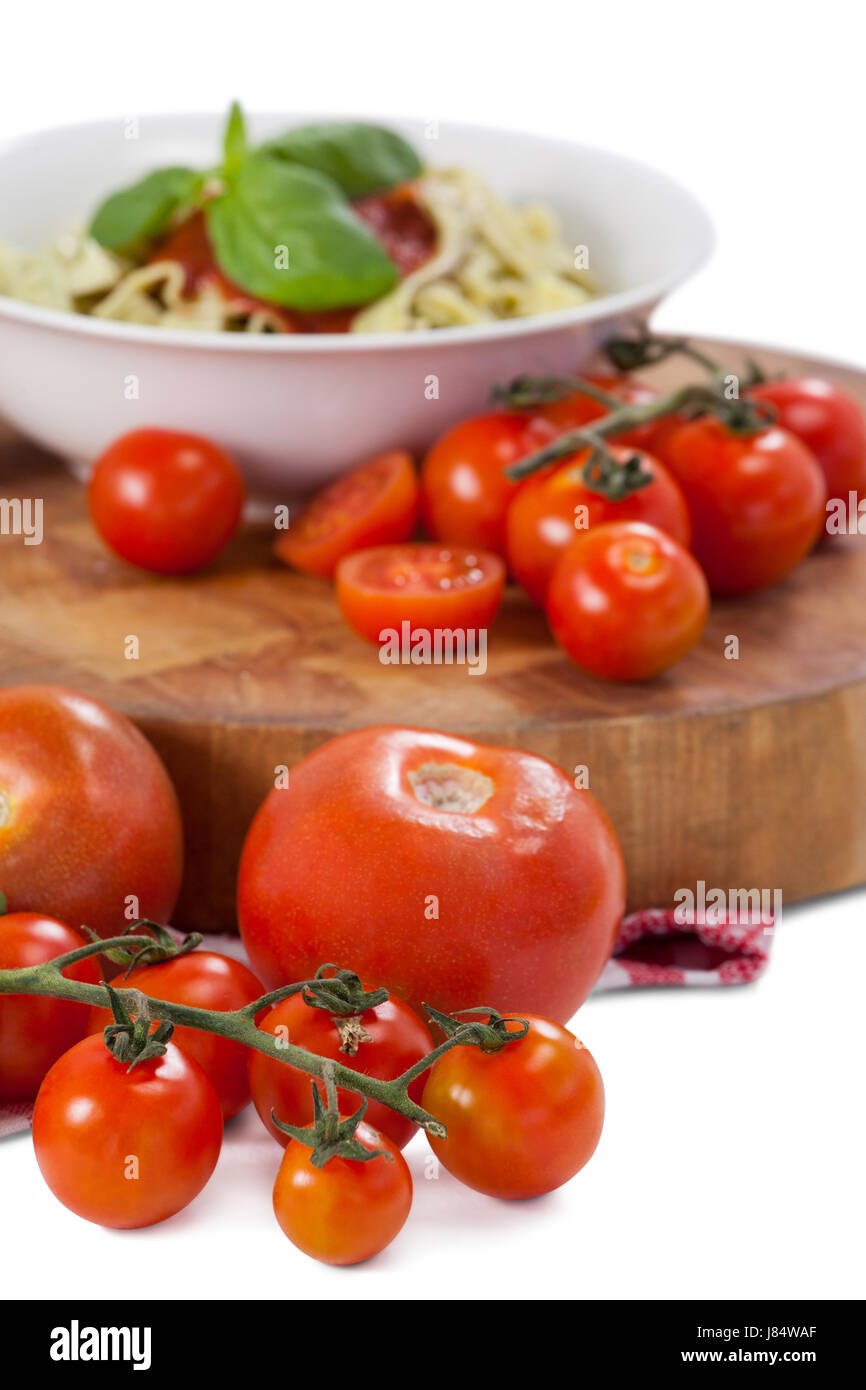 Fettuccine Nudeln mit Tomaten und Kräutern vor weißem Hintergrund Stockfoto