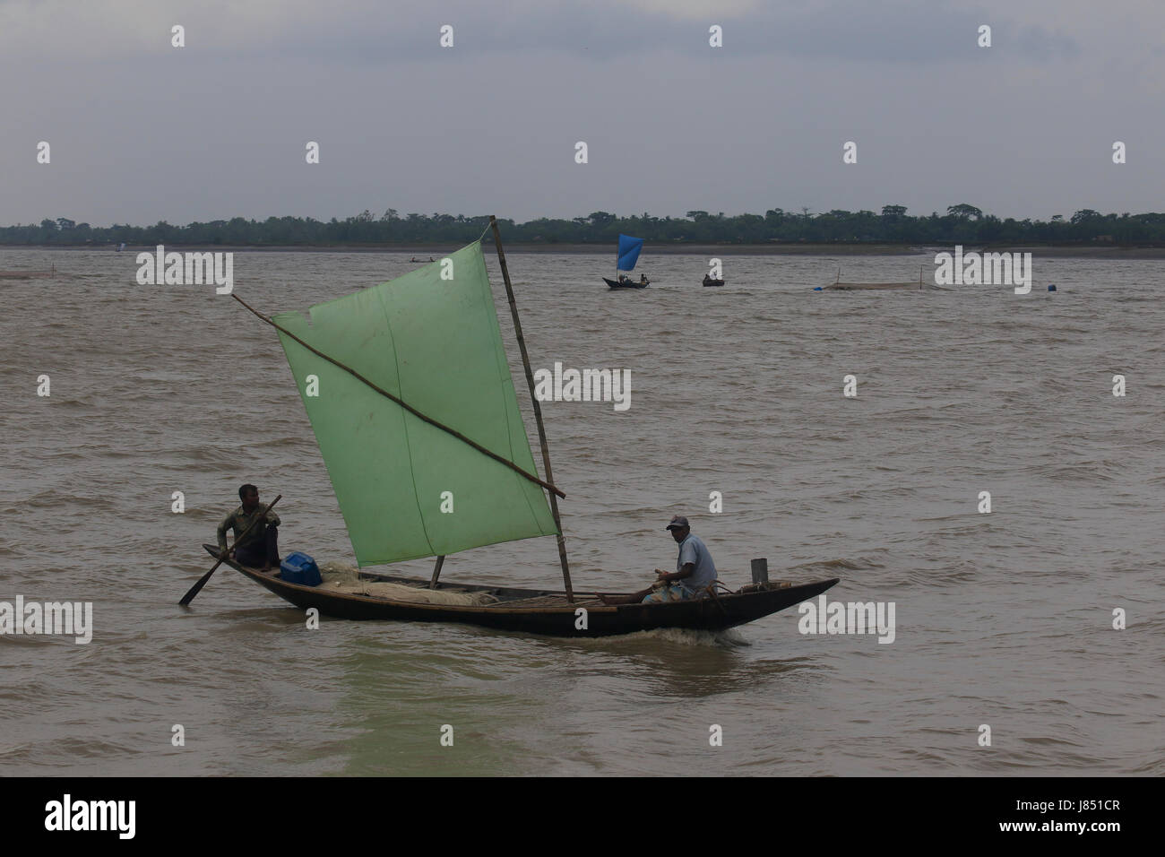 Fischer Angeln am Fluss Poshur mit einem Holzboot am Mongla. Bagerhat, Bangladesch. Stockfoto