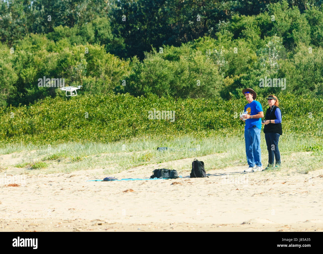 Paar eine DJI Phantom 4 Quadrocopter Drohne fliegen, am Strand, Gerroa, New-South.Wales, NSW, Australien Stockfoto