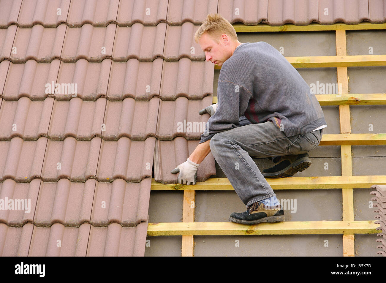 Hausbau Ziegel decken Ziegeldach Dachdecker auf dem Dach Bau Website Haus Stockfoto