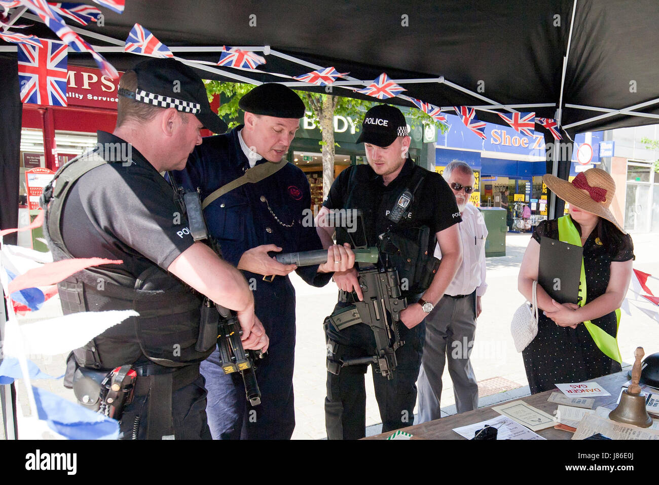 Lowestoft, UK. 24. Mai 2017. Bewaffnete Polizisten, interessieren Sie auf Patrouille im Stadtzentrum von Lowestoft einige Kriegszeit Erinnerungsstücke, darunter eine gefälschte Brandsatz an einem 1940er Jahren während des Krieges stand. Sie chatten mit Ian Pycroft, die, gekleidet wie ein Luftangriff Warden, eine der Attraktionen am Lowestoft 1940er Jahre Festival Wochenende über der geschäftigen Spring Bank Holiday Wochenende im Vereinigten Königreich gehostet hat. © Adrian Buck / Alamy Live News. Stockfoto