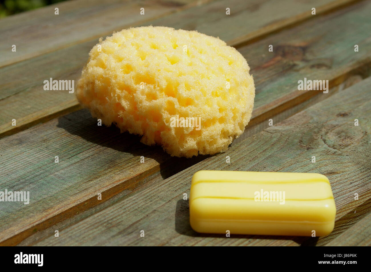gelben Schwamm und gelbe Seife auf Holzplatten Stockfoto