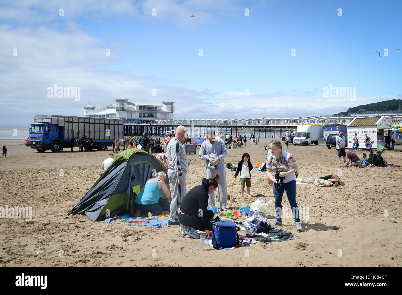 Menschen genießen das warme Wetter am Weston-super-Mare Strand, Briten, in der Hoffnung auf einen sengenden Feiertag enttäuscht sein mag, wie Meteorologen vorhersagen, dass Temperaturen startet am Samstag mit einer Chance von Regen und Gewitter während des langen Wochenendes fallen. Stockfoto