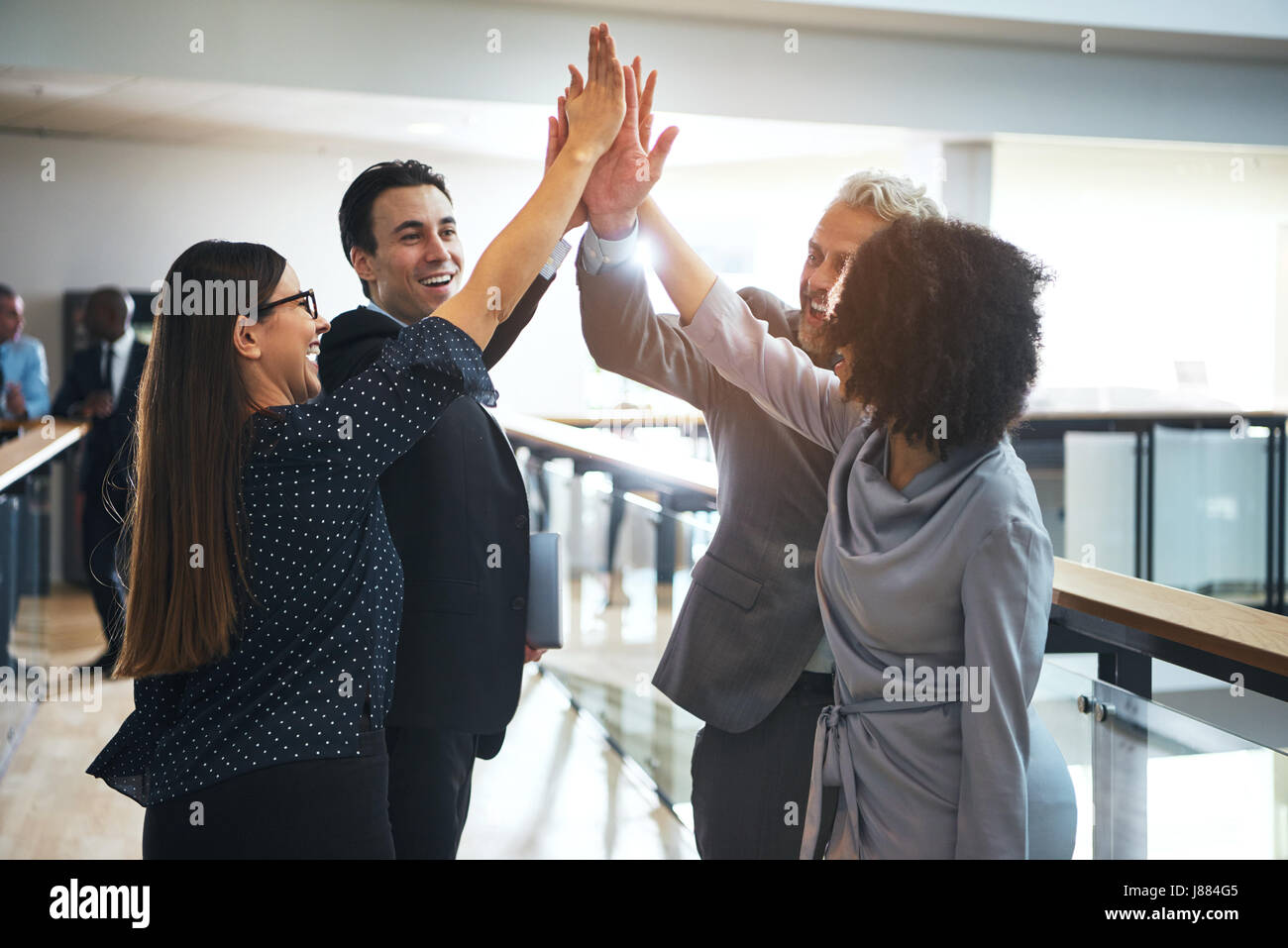Lächelnd Schwarz und Weiß business Leute stehen in Büro- und hohe fünf während Teambuilding. Stockfoto