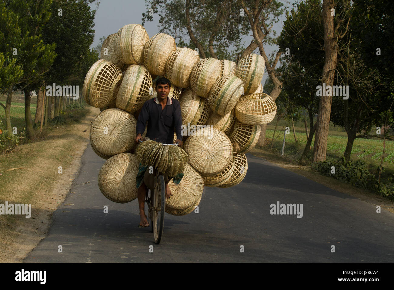 Ein Mann trägt Bambuskörben auf seinem Fahrrad. Meherpur, Bangladesch Stockfoto