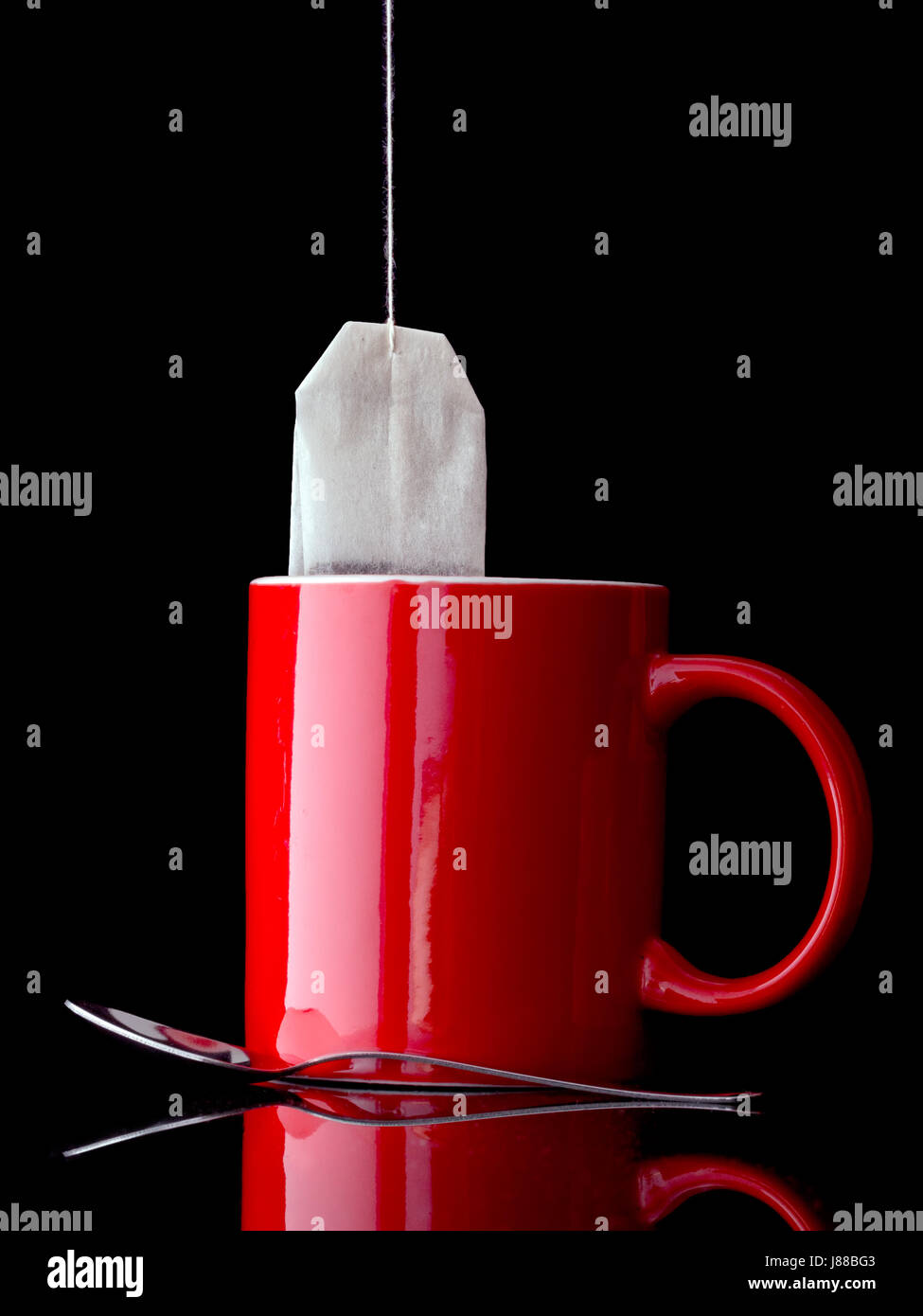 Rote Tasse Tee. Mit Löffel, aber ohne Zucker. Auch könnte Kräutertee etc. sein. Stockfoto