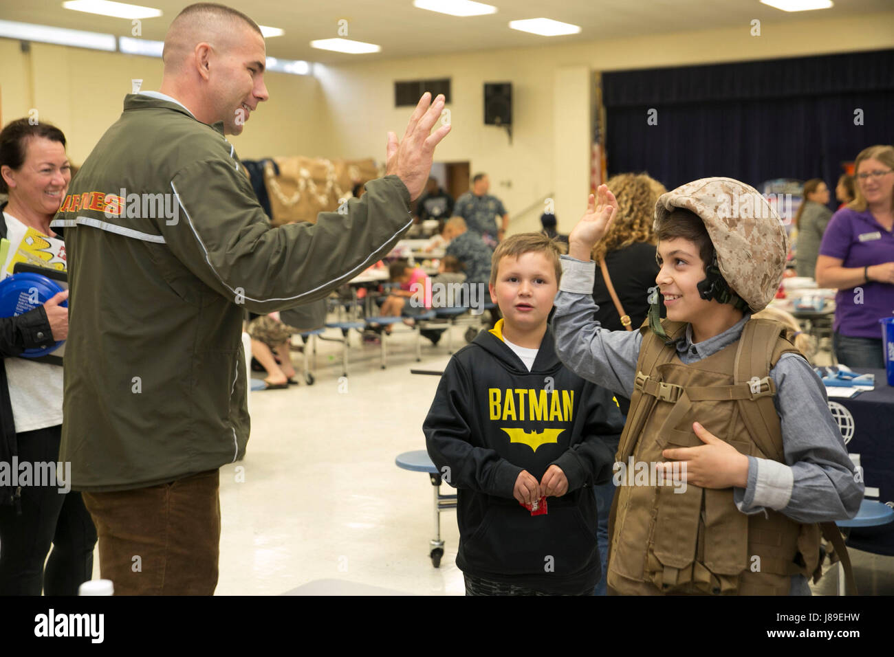 Staff Sgt William Hobson, Chef der Operationen, g-1, US Marine Corps Forces Command, high Fives ein Student an der Tarrallton elementare School in Norfolk, Virginia, nach hilft ihm taktische legte auf Ausrüstung wie Kevlar-Helm, Flak Weste und Rucksack, während eines militärischen Kind Wertschätzung, April 24. Die Veranstaltung fand statt, um den Schulen und Gemeinden in der Stadt Norfolk die Chance, Kinder von Service-Mitglieder erkennen. (Offizielle U.S. Marine Corps Foto von CPL. Logan Snyder / veröffentlicht) Stockfoto