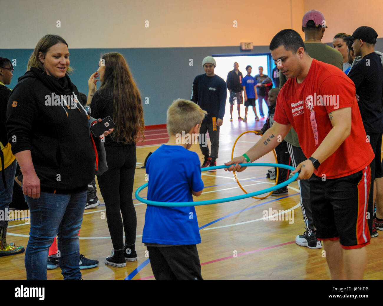 US Air Force Tech Sergeant Jonathan Garrett, 86. Fahrzeug Bereitschaft Squadron Ressource Berater hilft Kai, eine spezielle Olympian, Praxis für Hula Hoop Veranstaltung auf Ramstein Air Base, Deutschland, 19. Mai 2017. Die Hula Hoop-Veranstaltung gehörte zu mehreren Wettbewerben während der 2017 Frühling Kaiserslautern Military Community Special Olympics. Mehr als 70 Studenten nahm an Veranstaltungen, darunter Hula-Hoop, Tauziehen, Basketball-Fähigkeiten, Volleyball und mehr im Laufe des Tages. (Foto: U.S. Air Force Staff Sgt Timothy Moore) Stockfoto