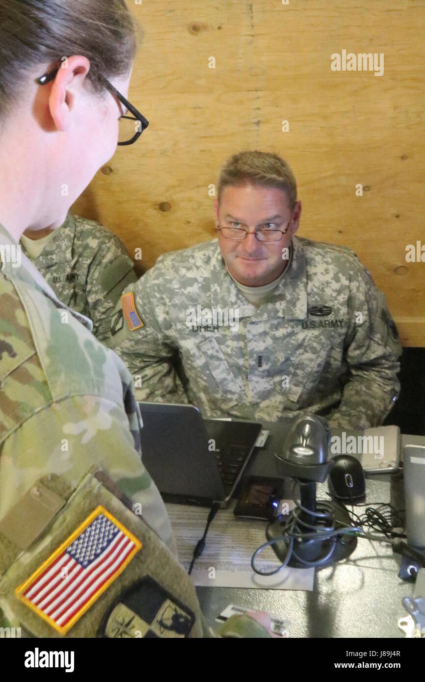 Chief Warrant Officer Ryan M. Uher, stellvertretender Offizier des Personals für die 184. Sustainment Command, Mississippi National Guard, in-Process-ein Soldat aus 2d Bataillon, 137. Infanterie-Regiment, Kansas National Guard 19. Mai 2017 im National Training Center in Fort Irwin, Kalifornien. Sie sind Bestandteil der 155. gepanzerte Brigade Combat Team, Mississippi National Guard und Training Teamarbeit aufzubauen und zu pflegen Kampfbereitschaft für zukünftige Missionen. (Mississippi National Guard Foto von Spc. Justin Humphreys, 102d Public Affairs-Abteilung). Stockfoto