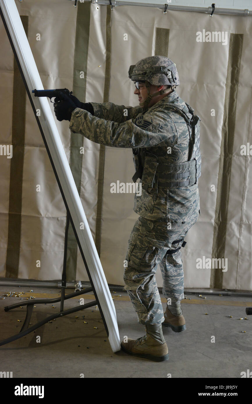 Staff Sgt Michael Blake, der 119. Sicherheit Kräfte Squadron, nimmt eine Schussposition, wie er in schießen teilnimmt, bewegen und Sicherheitstechniken Team Bewegung an der North Dakota Air National Guard Base, Fargo, ND, 19. Mai 2017 zu kommunizieren. Er schießt simulierte M9 Pistole Runden auf Ziele, als Teil einer jährlichen Sicherheit Trainingsanforderung Kräfte. (US Air National Guard Foto von Senior Master Sergeant David H. Lipp/freigegeben) Stockfoto