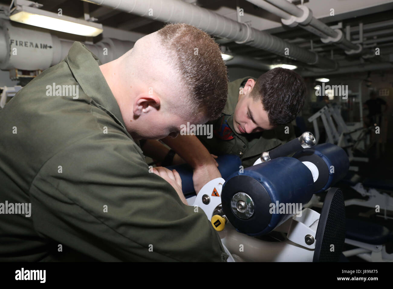 170522-N-HP188-0035 USA 5TH Flotte AREA OF OPERATIONS (22. Mai 2017) CPL Nicholas Collier, gebürtig aus Columbus, Indiana, und CPL. Cody Smith, gebürtig aus Pittsburg, Pennsylvania, an der "Blue Knights" der Marine Medium Tiltrotor Squadron (VMM) 365 (Stahlbeton), 24. Marine Expeditionary Unit angeschlossen Wartungsarbeiten an einer Bank Gewichtheben in der Turnhalle der amphibischen Angriff Schiff USS Bataan (LHD-5). Das Schiff und seine bereit-Gruppe sind in den USA im Einsatz 5. Flotte Bereich der Maßnahmen zur Erhöhung der Sicherheit im Seeverkehr Operationen, Verbündete und Partner zu beruhigen und bewahren die Freiheit des Nav Stockfoto
