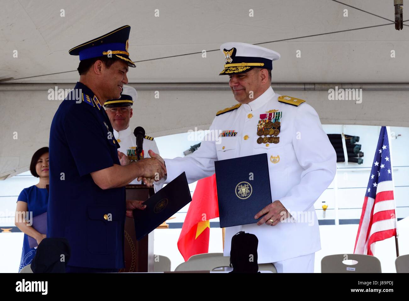 Schütteln Sie Lt. General Nguyen Quang Dam, Kommandant, Vietnam Küstenwache und Rear Admiral Michael J. Haycock, stellvertretender Kommandant für Erwerb und Leiter Akquisition Officer, U.S. Coast Guard, Hände während einer Übertragung Zeremonie im Coast Guard Base Honolulu, 25. Mai 2017. Kutter jetzt CSB-8020, wird weiterhin der maritime Gemeinschaft auf der gegenüberliegenden Seite des Pazifiks zu dienen. (Foto: U.S. Coast Guard Petty Officer 2. Klasse Melissa E. McKenzie/freigegeben) Stockfoto