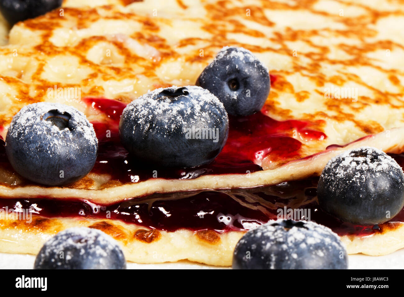 Nahaufnahme von Heidelbeeren auf Pfannkuchen mit Konfitüre Stockfoto